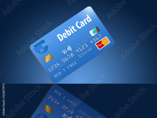 A debit card in blue is seen on a dramatic blue background on a reflective tabletop. This is a photo illustration combining photographs with artwork and is free of copyright. Cards are generic and saf photo