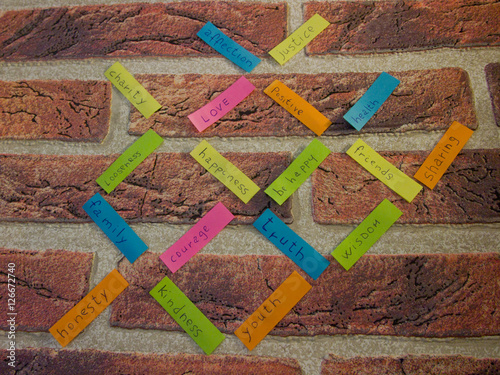 Messaggi positivi scritti su dei post it attaccati su un muro di mattoni rossi