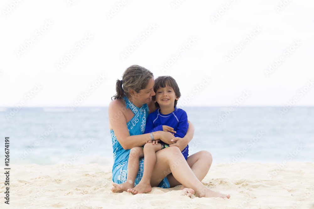 Lovely Mother and Boy Sitting on the Beach