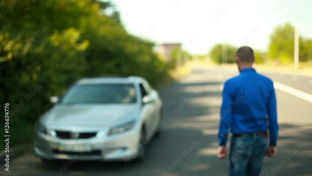 Young man showing keys from car goes to his car Young man showing keys from car goes to his car