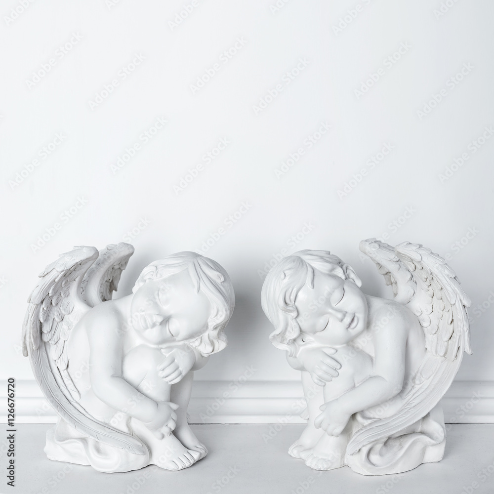 Obraz premium Statues of Sleeping Cupids on white background with copy space for text