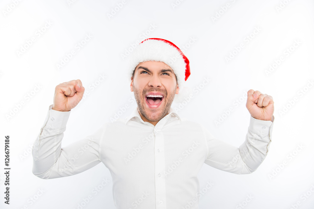 Excited happy man in santa's hat celebrating new year and triump Excited happy man in santa's hat celebrating new year and triump