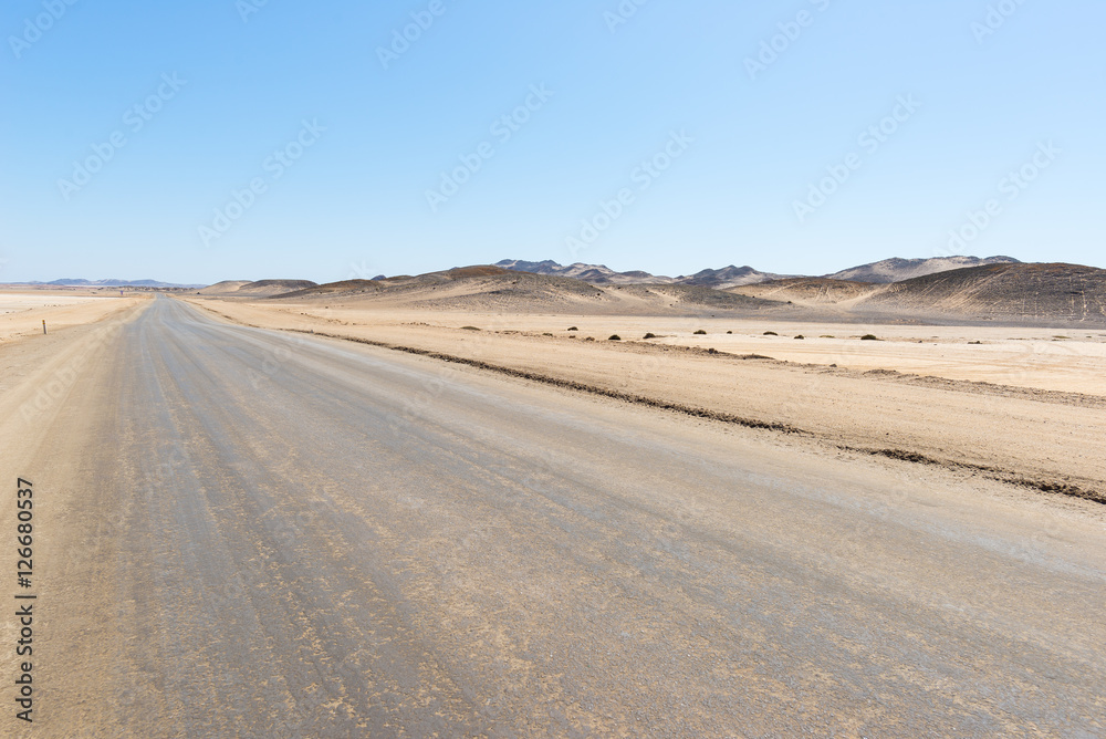 Salt road crossing the Namib desert, in the majestic Namib Naukluft National Park, best travel destination in Namibia, Africa. From Walvis Bay to Swakopmund, Henties Bay and the Skeleton Coast. Salt road crossing the Namib desert, in the majestic Namib Naukluft National Park, best travel destination in Namibia, Africa. From Walvis Bay to Swakopmund, Henties Bay and the Skeleton Coast.