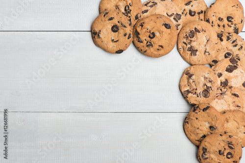 Vintage wooden background with tasty chocolate chip cookies, copy space