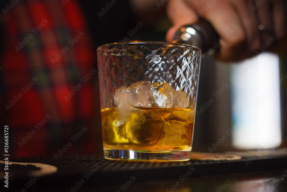 Bartender pours whiskey with ice closeup Bartender pours whiskey with ice closeup