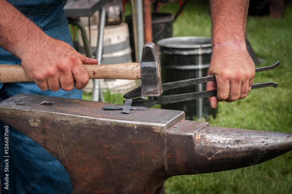 Blacksmith Straightens Cross Arm on Anvil Blacksmith Straightens Cross Arm on Anvil