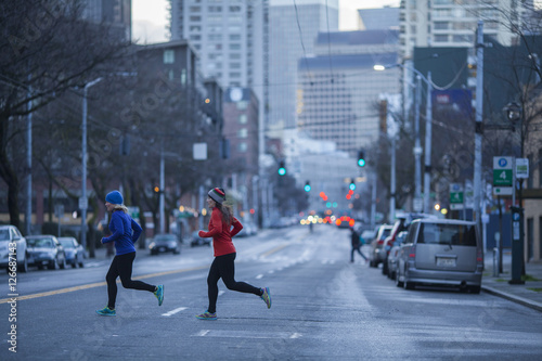 Two adult women running across a Seattle street. Washington State