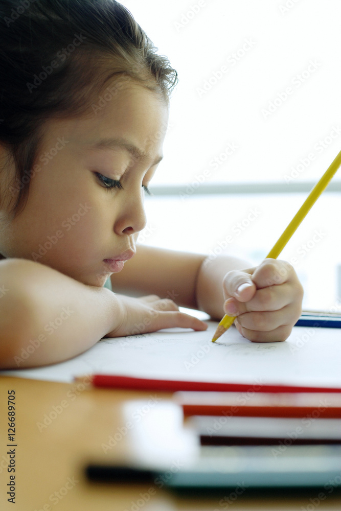 Young girl drawing, resting chin on arm, sideview Young girl drawing, resting chin on arm, sideview