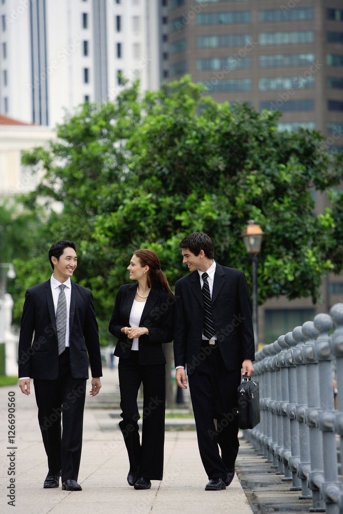 Business people walking side by side, talking Business people walking side by side, talking