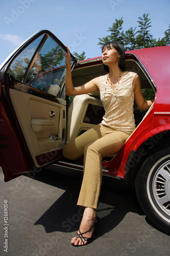 Obraz na płótnie Woman getting out of red car w salonie