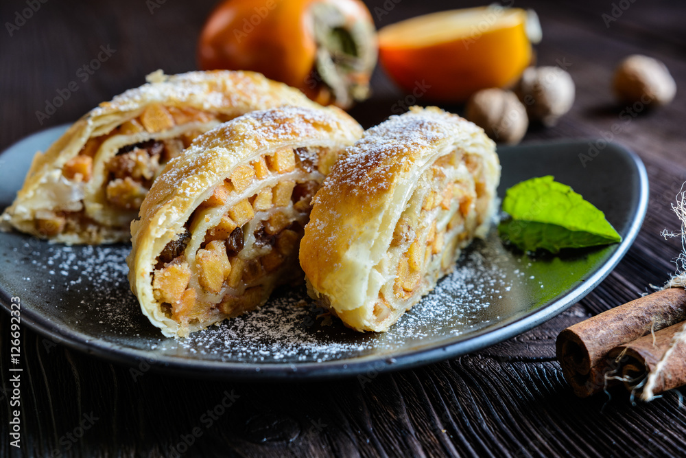 Sweet strudel with persimmons, raisins and walnuts