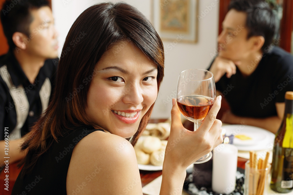 Woman with wine glass, looking over shoulder, smiling Woman with wine glass, looking over shoulder, smiling