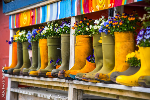 Stivali pieni di fiori molto colorati su piano in legno photo