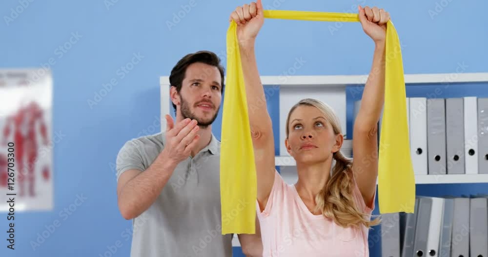 Physiotherapist training female patient with exercise band Physiotherapist training female patient with exercise band