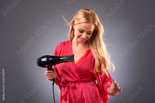 Canvastavla Young woman with hairdryer