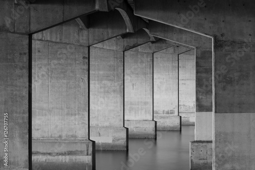 Support pillars for Auckland Harbor Bridge with glossy water and concrete frame