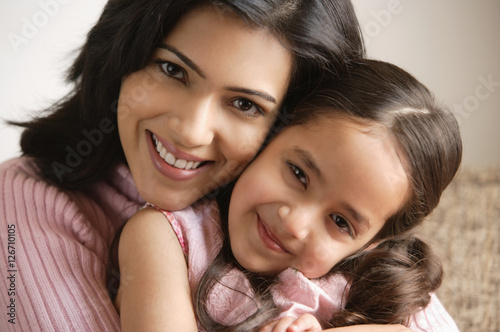 Obraz na płótnie close up of mother and daughter hugging and smiling at camera w salonie