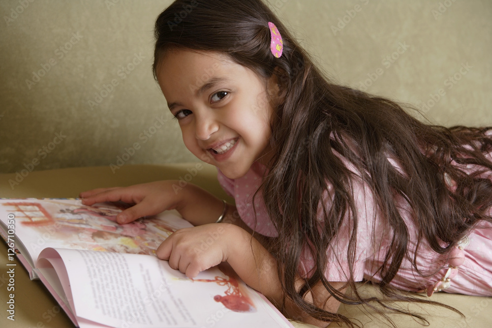 girl with story book smiling at camera