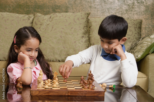 Photography boy and girl play chess