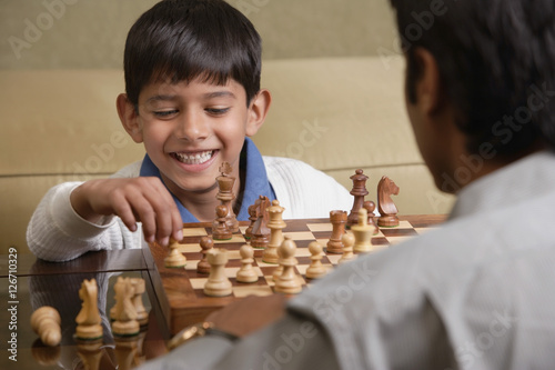 Photography boy plays chess with father and smiles (horizontal)