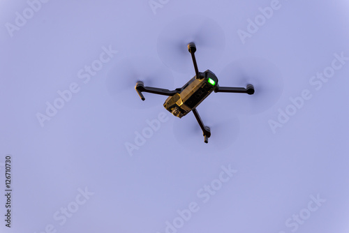 Close up of small modern drone taking photo while hovering