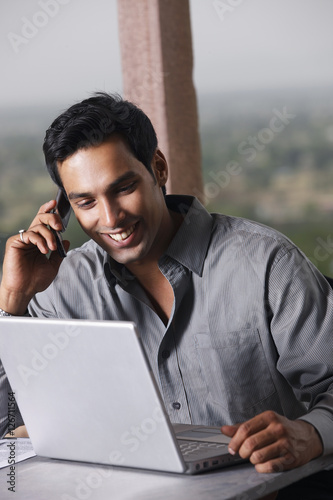 Photography man on phone, working at laptop computer