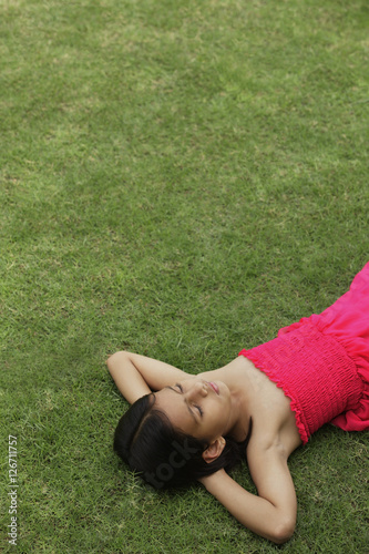 little girl in pink dress sleeping in park © Alexander