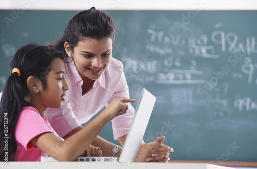 teacher and student at laptop, girl pointing at screen