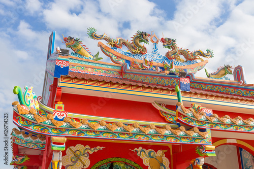 Golden dragon statue on public shrine roof, Thailand, Dragon prominently in the beautiful on blue sky background