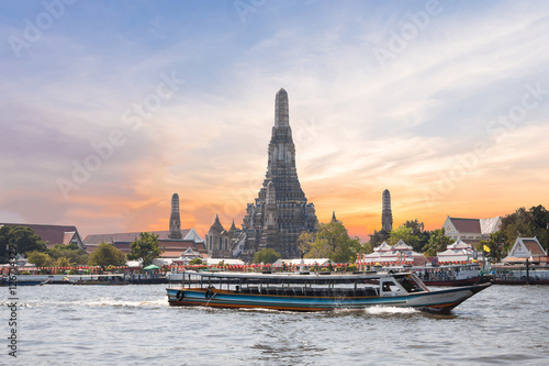 The Temple of Dawn, Wat Arun, on the Chao Phraya river with passenger ships or boat and a beautiful sky in twilight time at Bangkok, Thailand © powerbeephoto