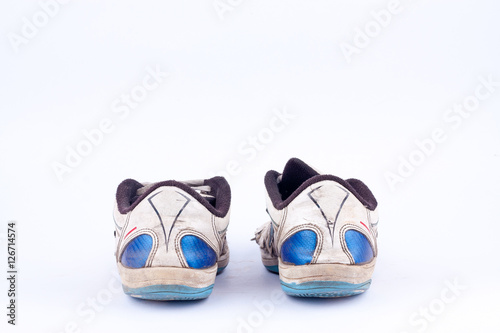 Old retro worn out futsal sports shoes on white background isolated ( back view ) 