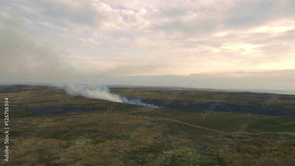 Burning grass fields in the hills, UK, England. Aerial view Burning grass fields in the hills, UK, England. Aerial view
