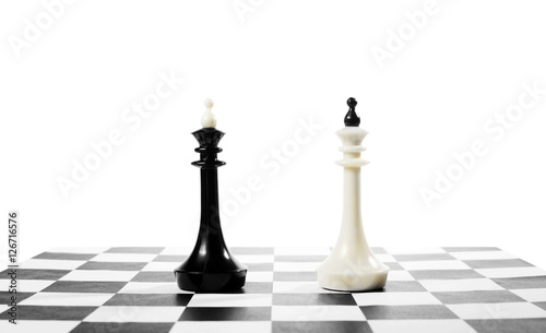 Two chess kings one in front of other. Battle of equal competitors. Concept with chess pieces against white background