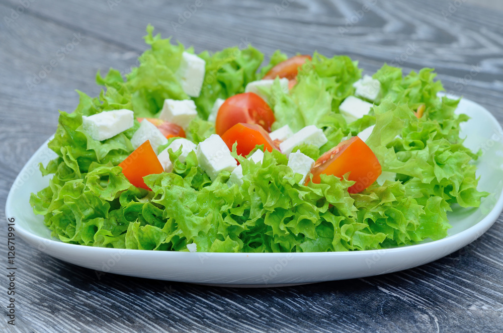 salad with cheese and tomato in white dish on table salad with cheese and tomato in white dish on table