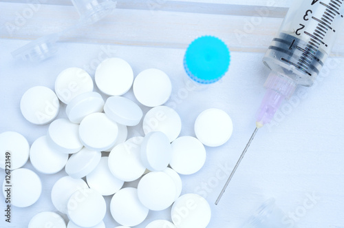 white pill and syringe