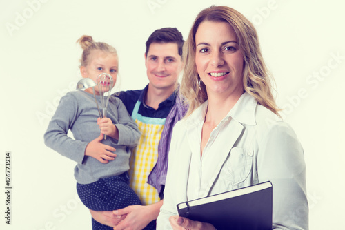 young blond businesswoman and her husband with child in backgrou