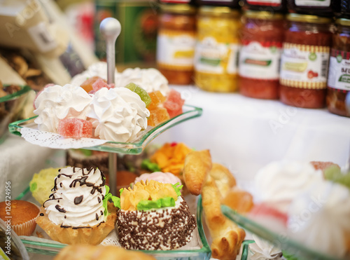 Obraz na płótnie sweet cakes on glass plate for event and jars with fruit jam as w salonie