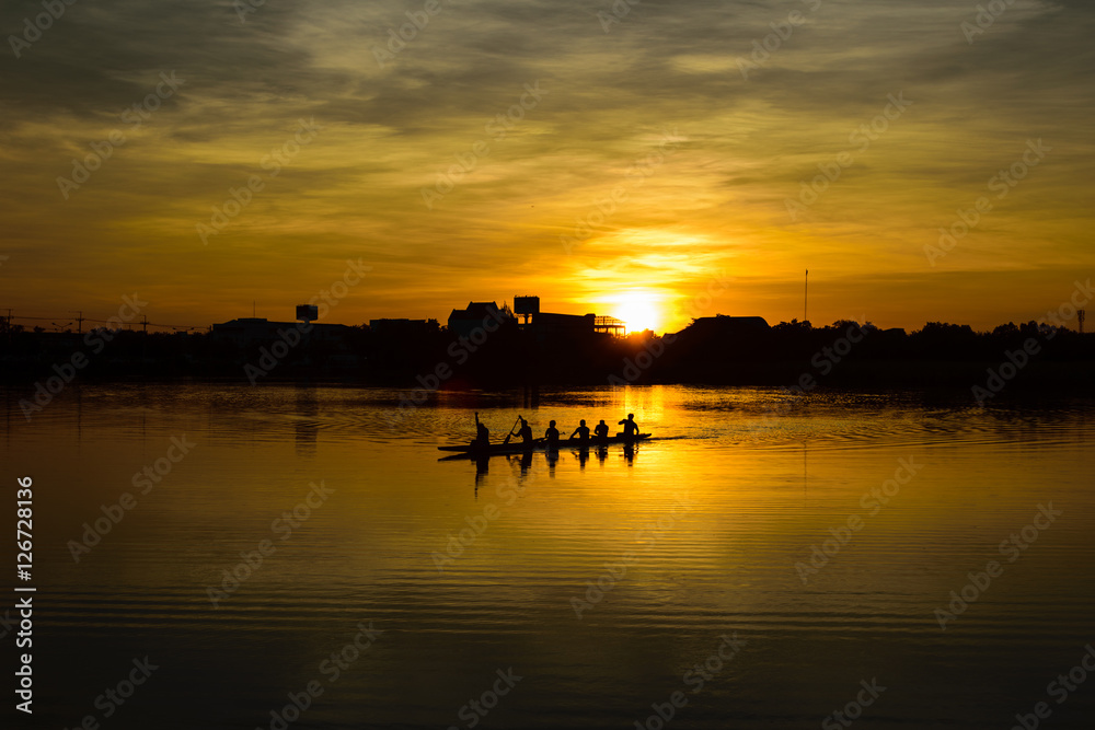 people paddle in the lake at sunset time, silhouette, teamwork concept