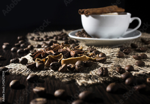 cup of hot coffee, cinnamon, star anise,lemon and coffee beans