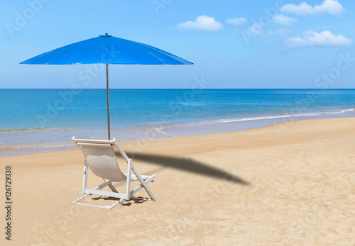 Fototapeta Naklejka Na Ścianę i Meble -  white wooden beach chair and blue parasol on tropical beach 