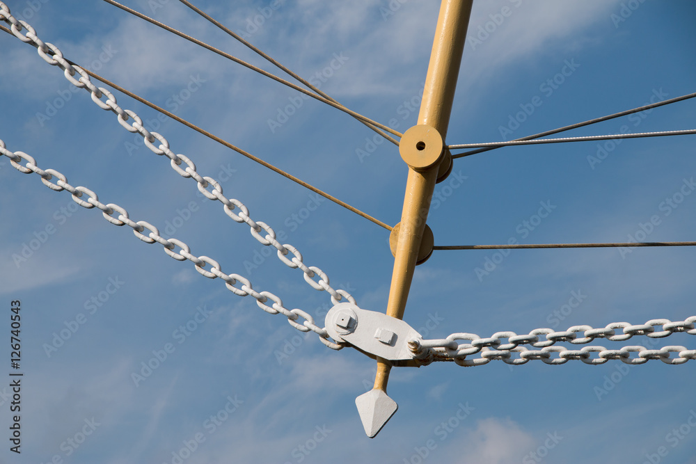 Obraz premium Vintage sailing ship mast ropes and tackle, Tall ship rigging mast detail, blue sky background