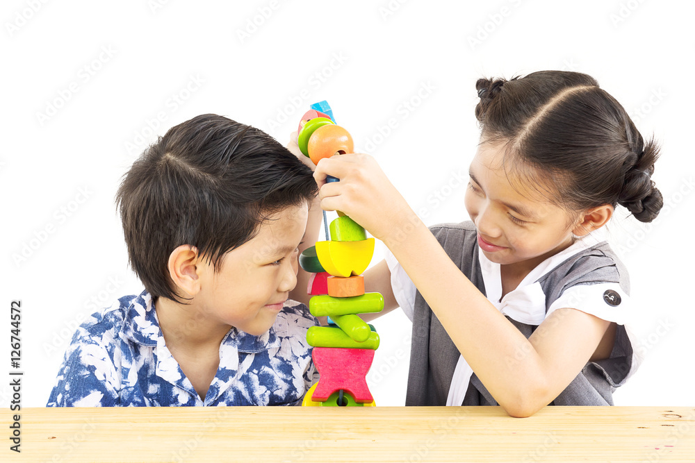 Asian boy and girl are happily playing colorful wood block toy Asian boy and girl are happily playing colorful wood block toy