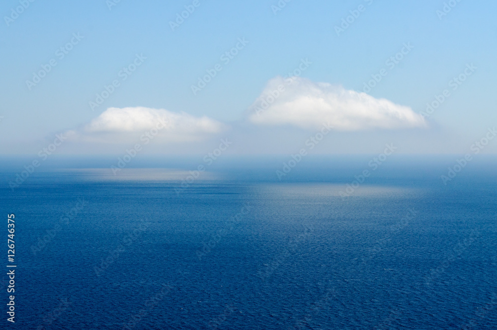 two clouds reflected in the sea water