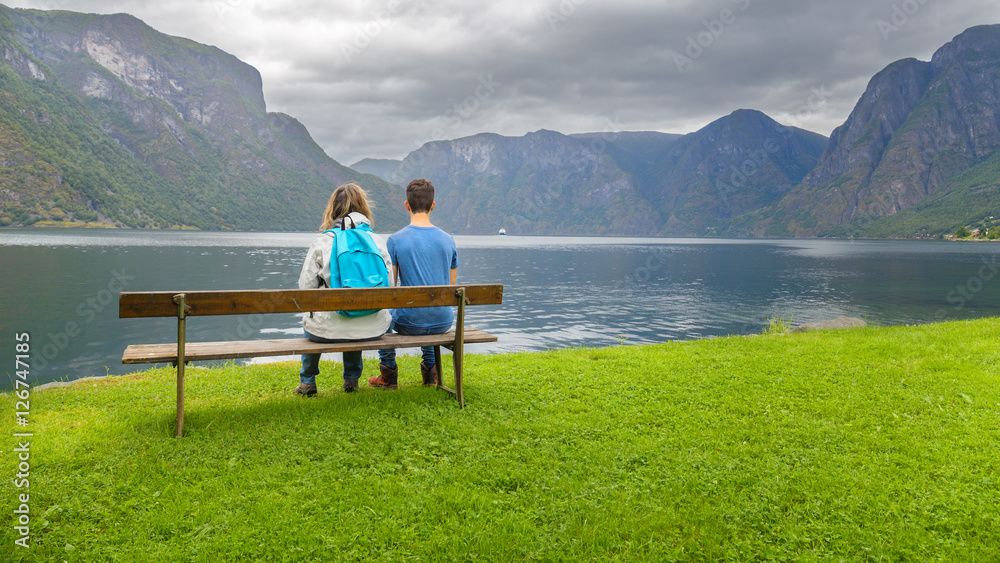 Mother and son sitting on a bench  looking at the fjord in Ulvik
