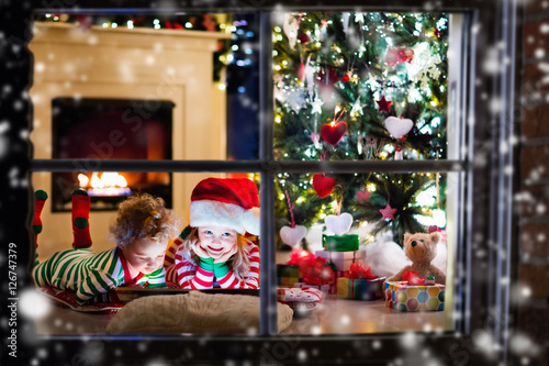 Kids in pajamas under Christmas tree