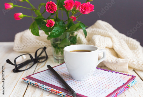 Warm knitted plaid, glasses, coffee, notebook and pensil