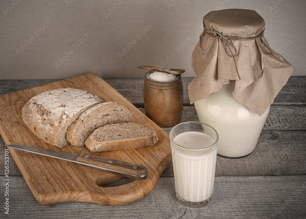 glass of milk and fresh homemade bread with solt on wooden table