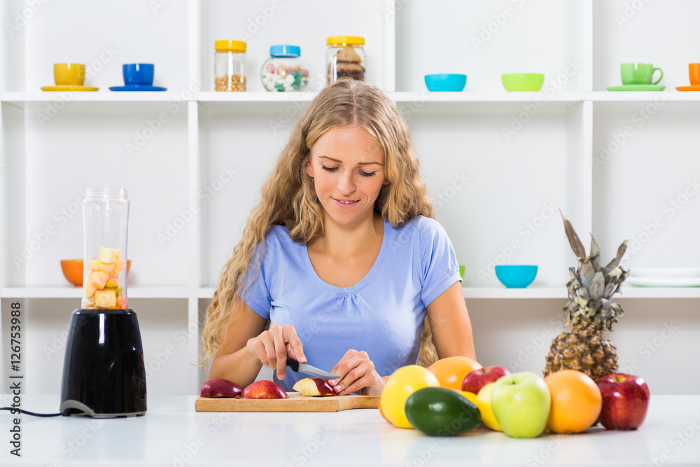 Beautiful girl enjoys making smoothie at her home.
Beautiful girl enjoys making smoothie at her home.