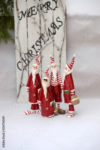 cool christmas, 4 funny santa claus figures, one of them wearing sun glases, in front of a descreet christmas decoration photo