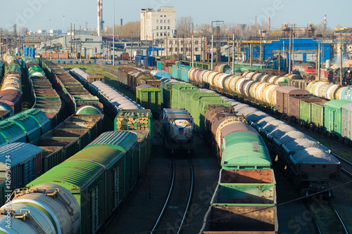 Train cargo station with lots of cars tanks and semi-trailers.